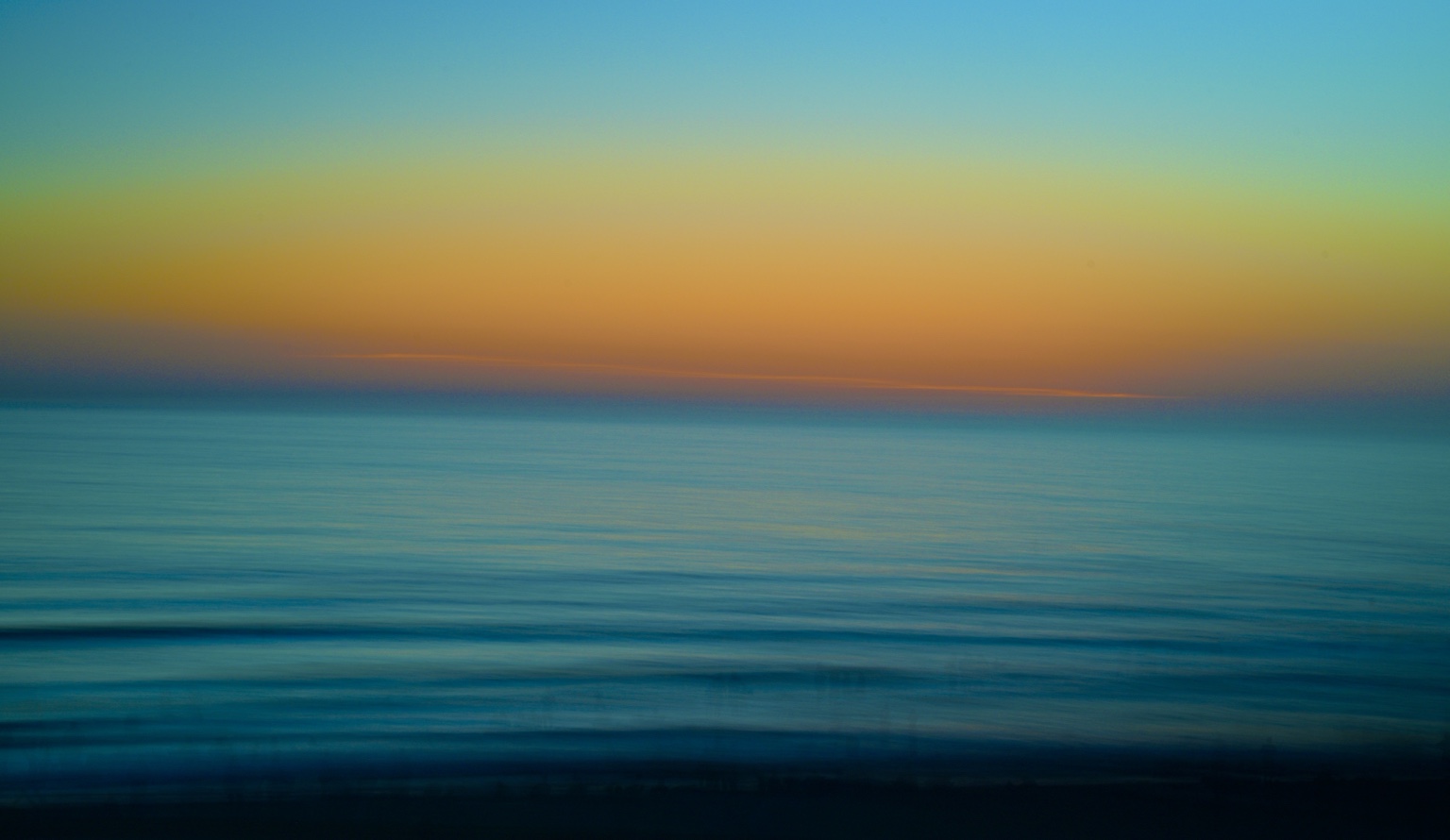 Abstract bands of blue water and coral sunset light