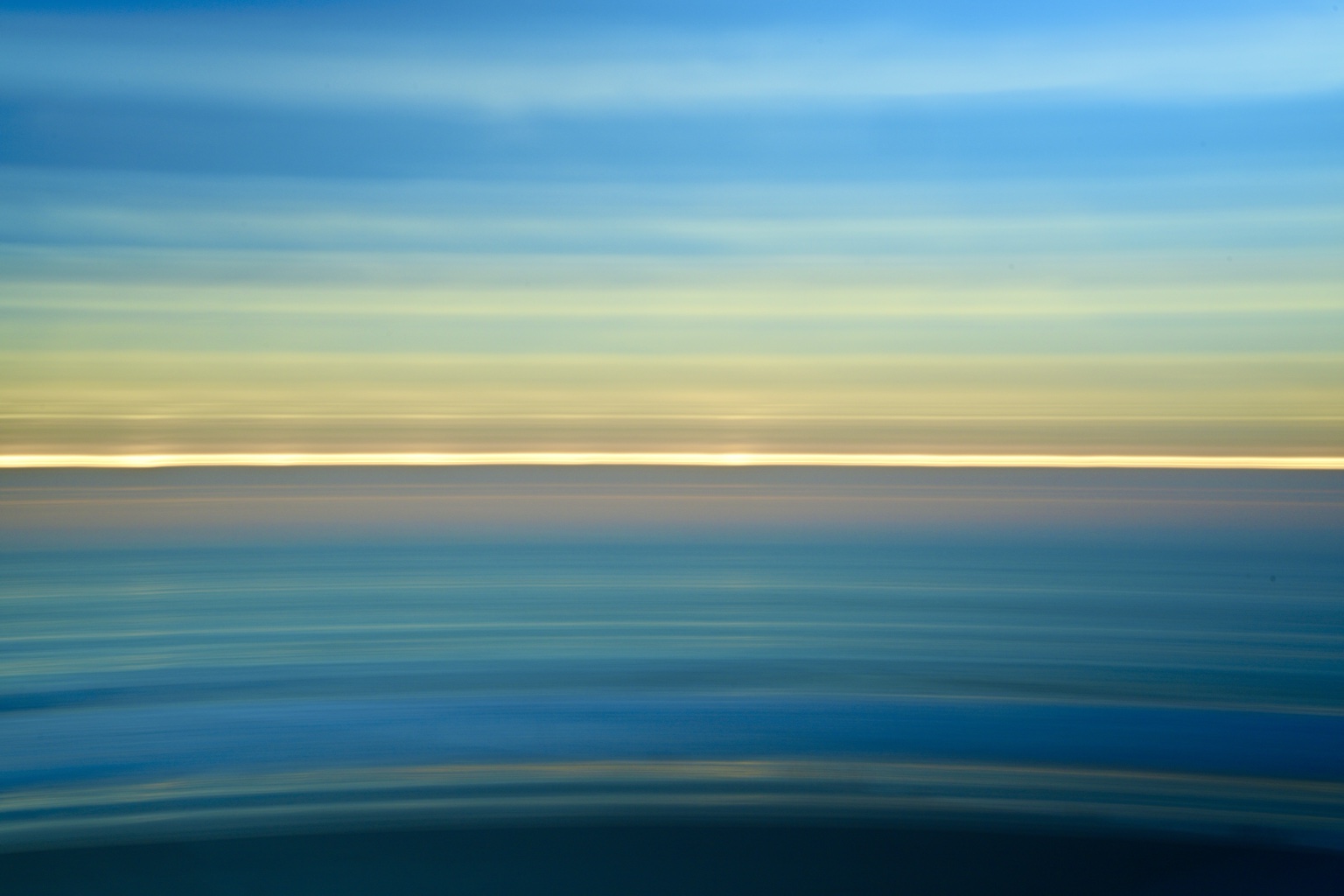 Deep blue abstract seascape divided by a luminous horizon